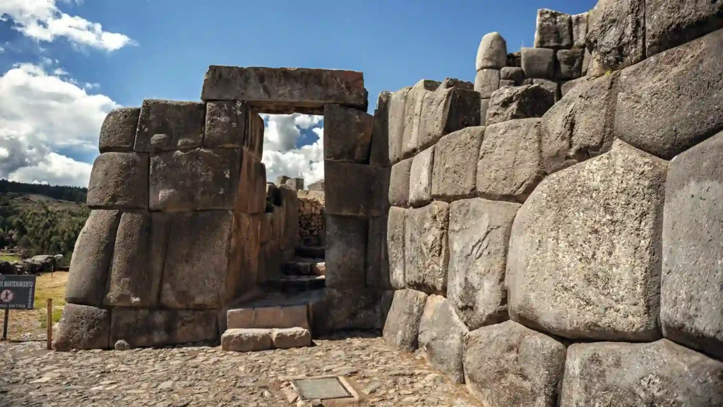 Turistas explorando la fortaleza de Sacsayhuamán durante el City Tour Cusco por la tarde.