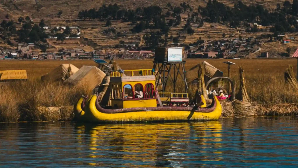 Balsa tradicional de totora navegando en el Lago Titicaca frente a las islas de los Uros en Puno.