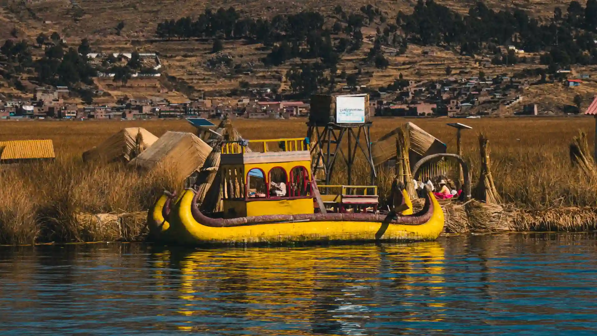 Balsa tradicional de totora navegando en el Lago Titicaca frente a las islas de los Uros en Puno. paquete Lima Cusco Puno 9 días
