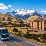 Bus turístico recorriendo la Ruta del Sol entre Cusco y Puno rodeado de paisajes andinos - Llamitas Travel