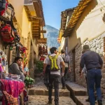 Turistas paseando por las calles empedradas de Cusco y bailarines folclóricos con trajes típicos - Llamitas Travel